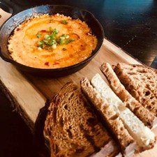 Warm skillet appetizer served with sliced toasted bread at Blueprint on 3rd in Birmingham