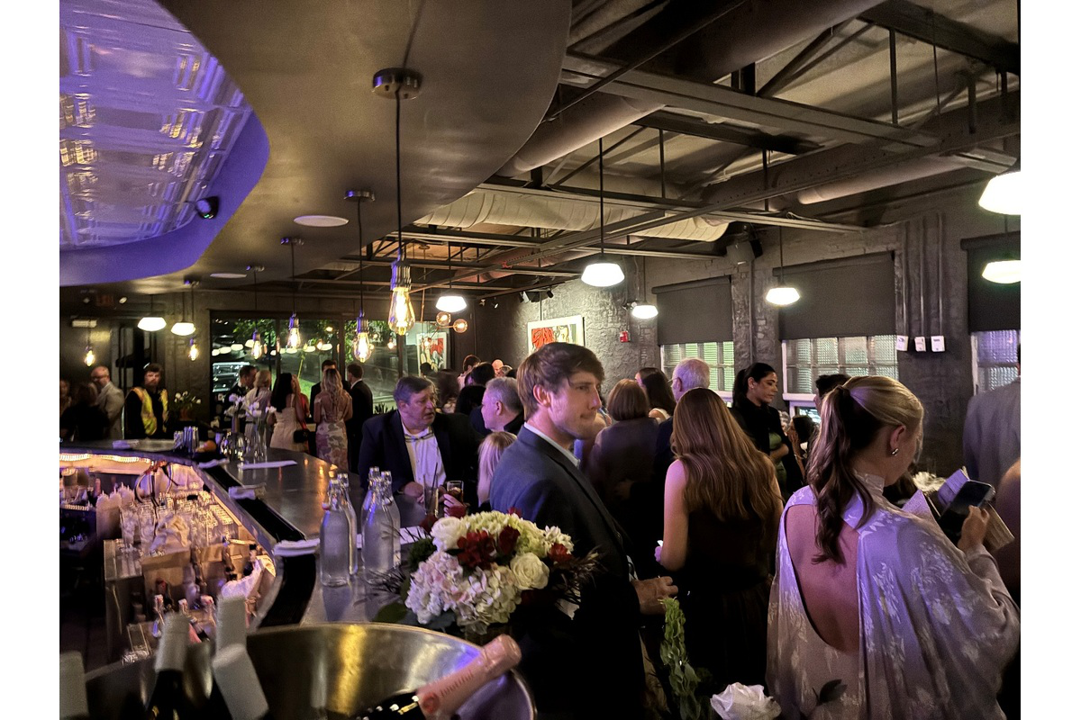 Guests gathering beside the curved zinc bar during a private event at Blueprint on 3rd in Birmingham