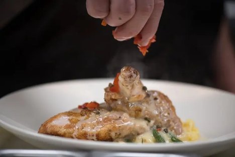 Chef adding a finishing garnish to a plated entree at Blueprint on 3rd in Birmingham