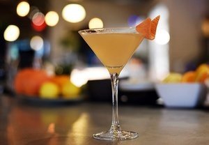 Citrus-colored craft cocktail in a martini glass at the bar at Blueprint on 3rd in Birmingham