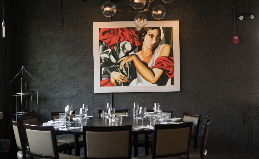 Intimate dining room at Blueprint on 3rd in Birmingham with a round table and framed artwork